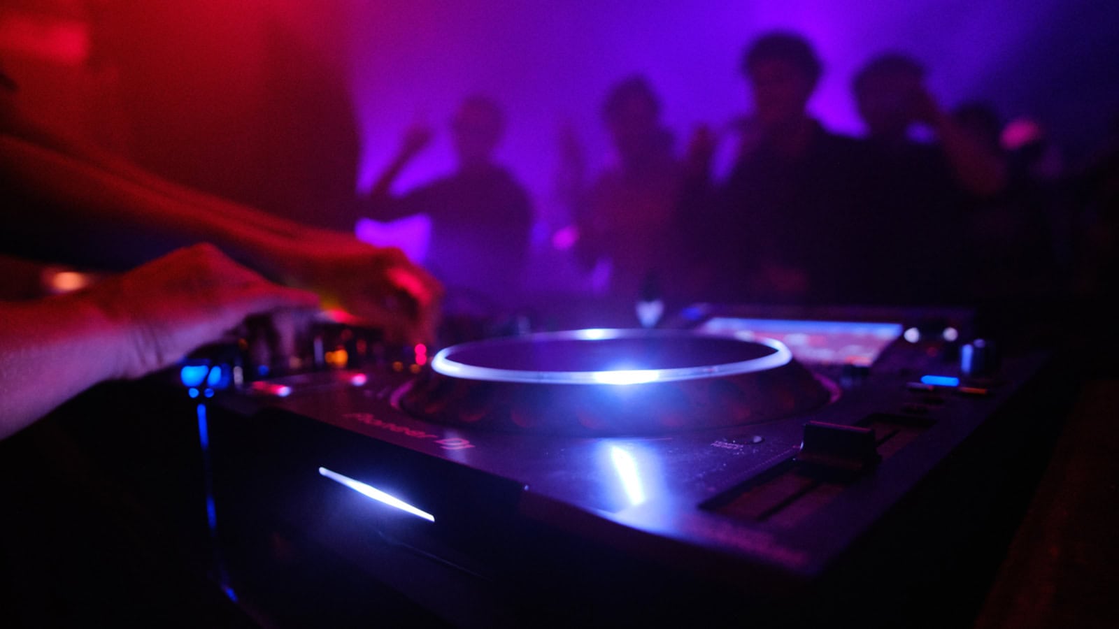 A closeup shot of DJ's equipment and the people dancing in the club Ladida, Metropolis London