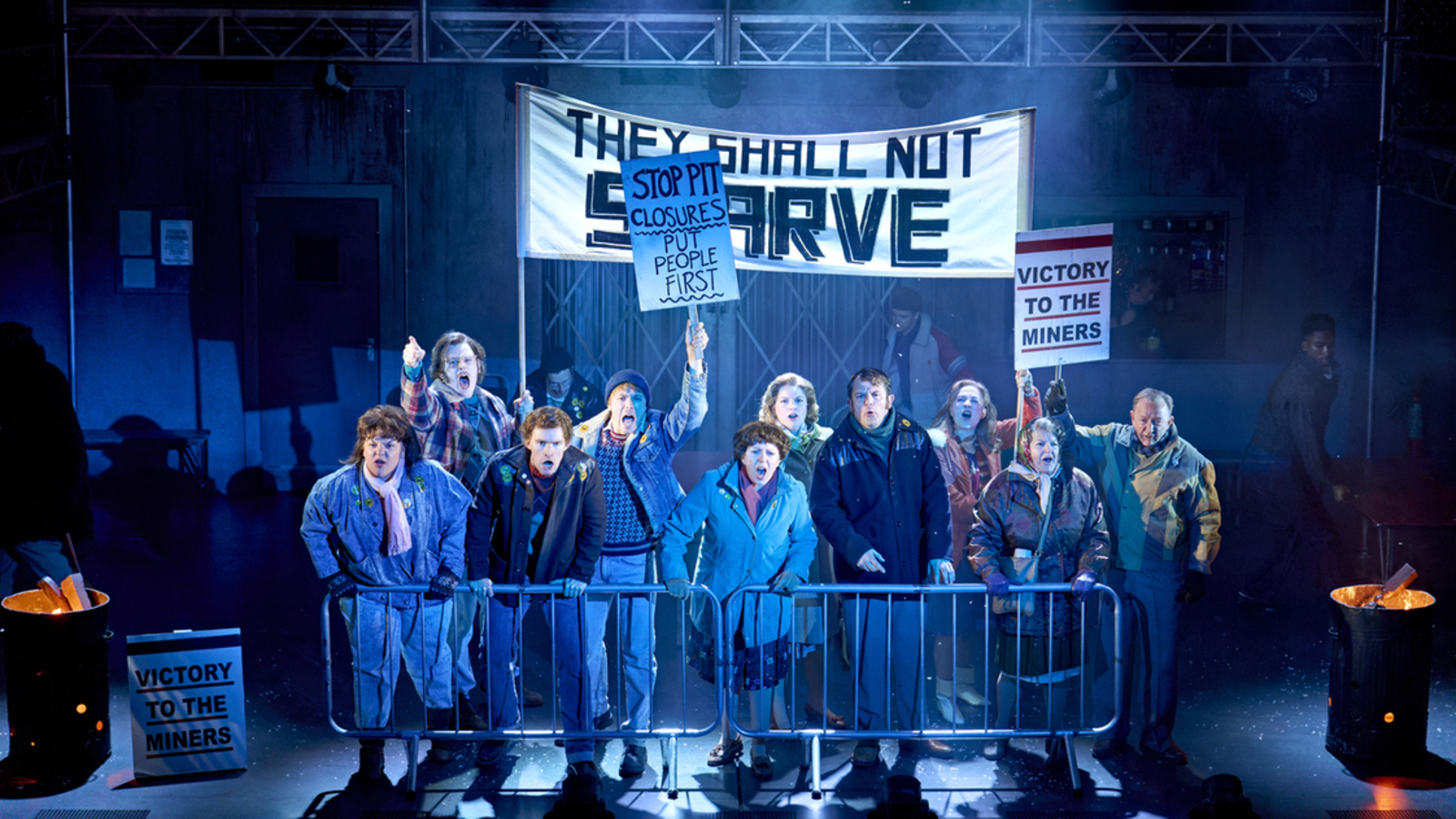 Crowd image of a demonstration on stage at musical production of Pride The Musical.